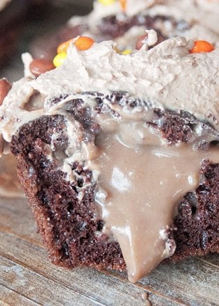 The PMS Buster - Chocolate Peanut Butter Filled Cupcakes with the world's best buttercream recipe: Chocolate Peanut Butter Frosting. Must try dessert recipe!