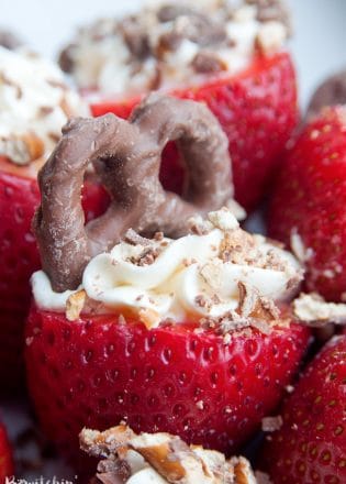 Cheesecake Stuffed Strawberries. This easy, no bake dessert recipe is a party favorite. Cream cheese, sugar and vanilla, topped with crunchy milk chocolate covered pretzels makes this bite sized treat sweet, salty and crunchy. Add this to your popular desserts board.