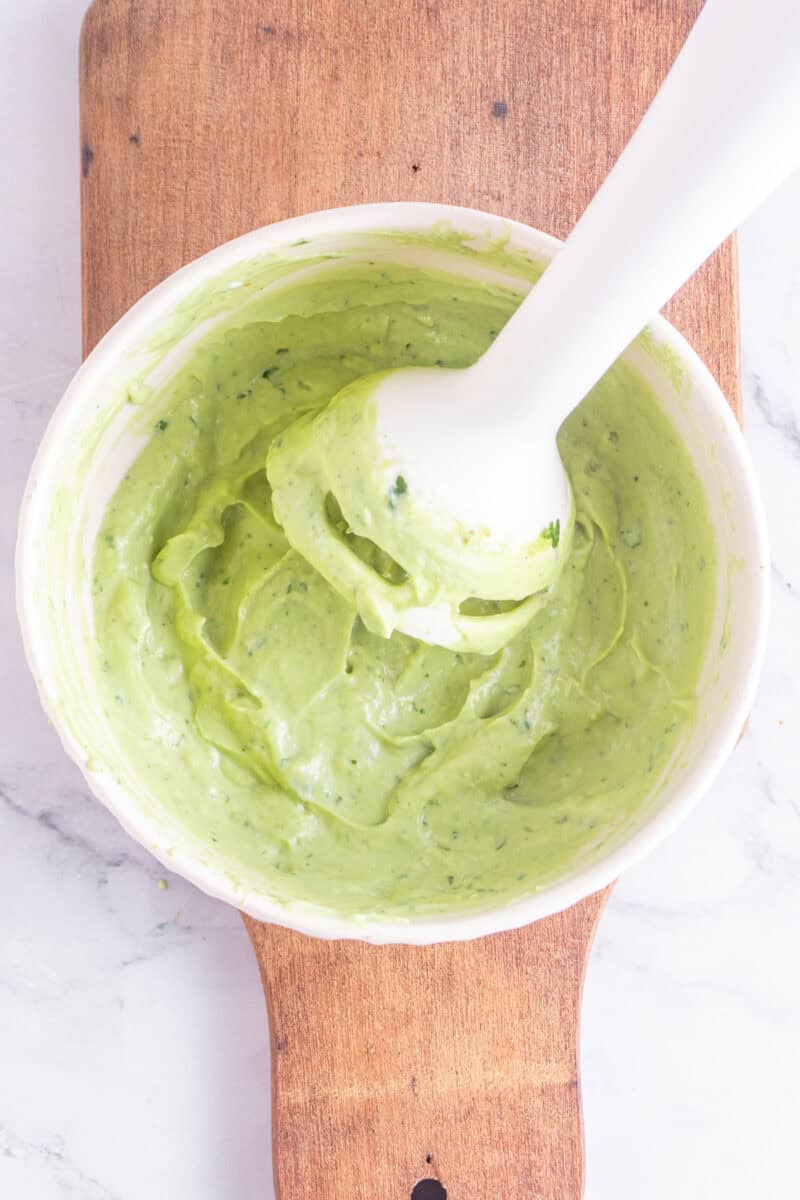 avocado crema in a bowl with a hand blender