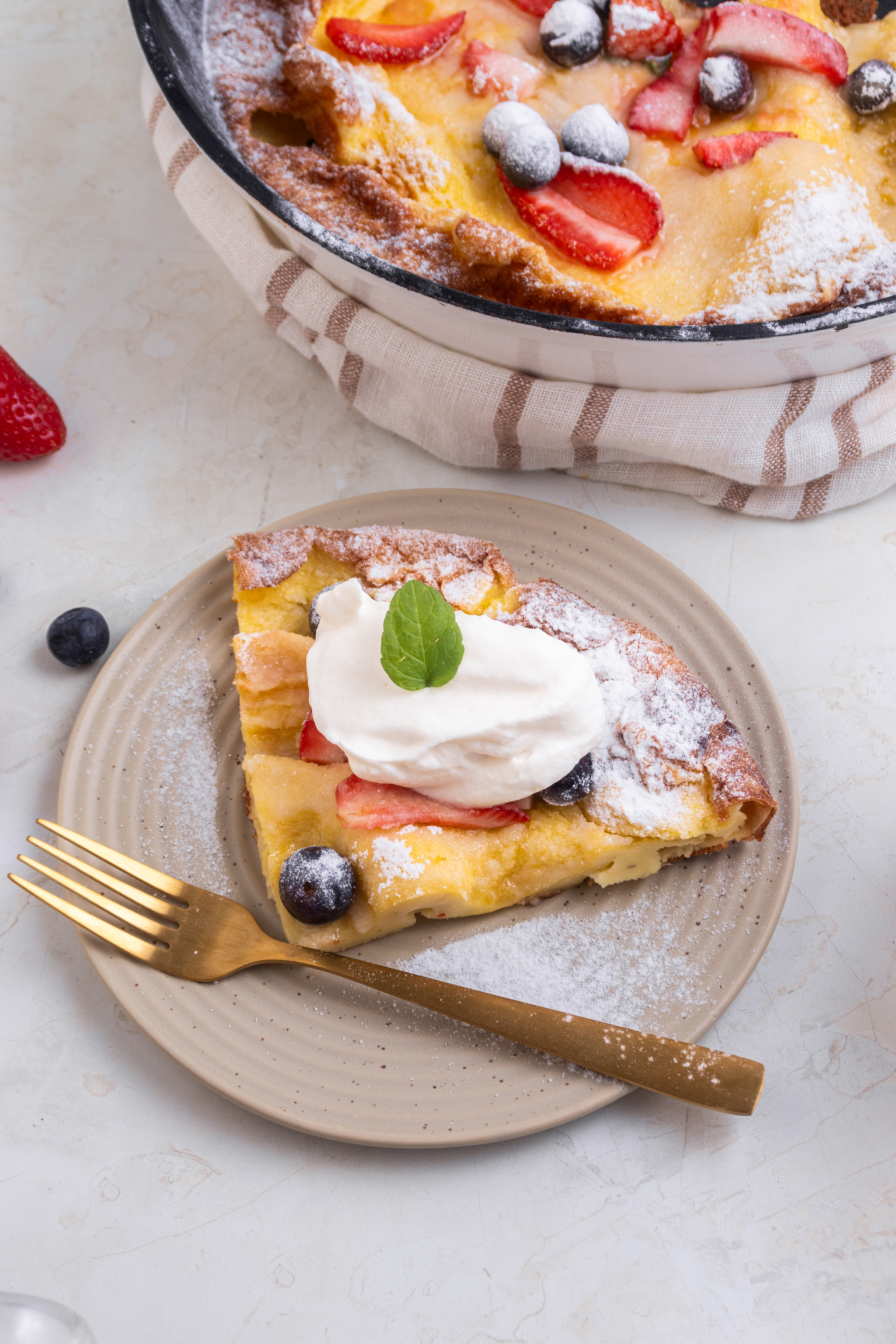 dutch baby pancake on a plate with whip cream