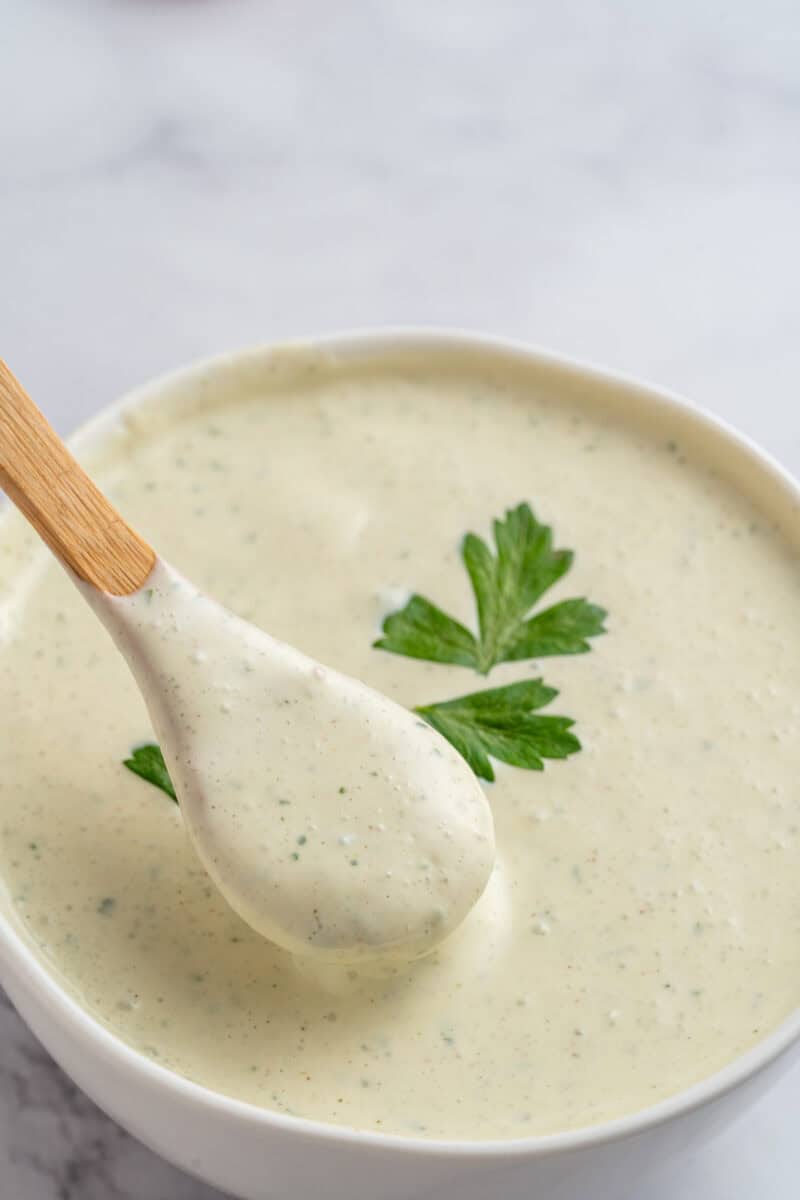 Greek yogurt salad dressing in a bowl with a wooden spoon