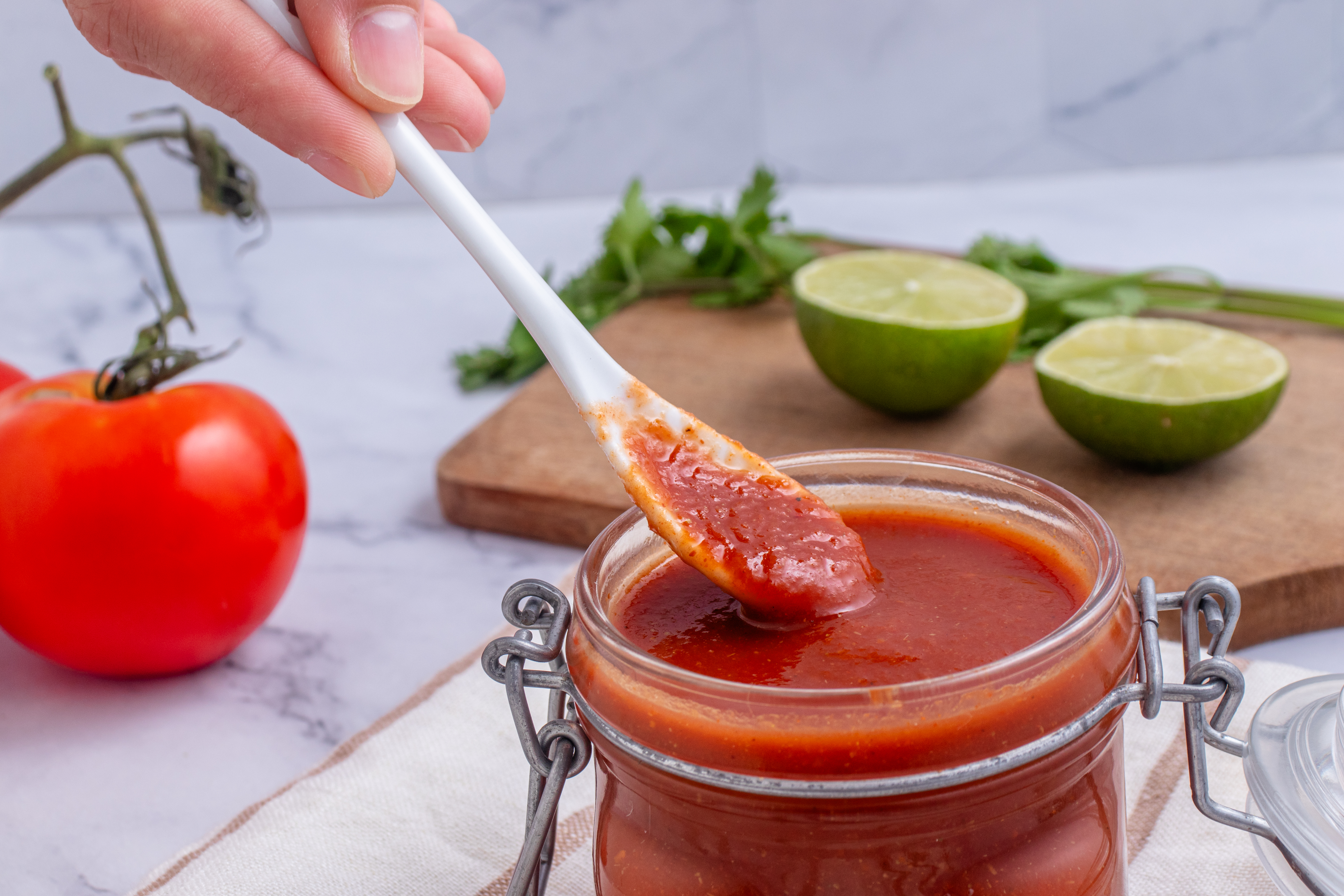 taco sauce in a jar with a person holding a spoonfull