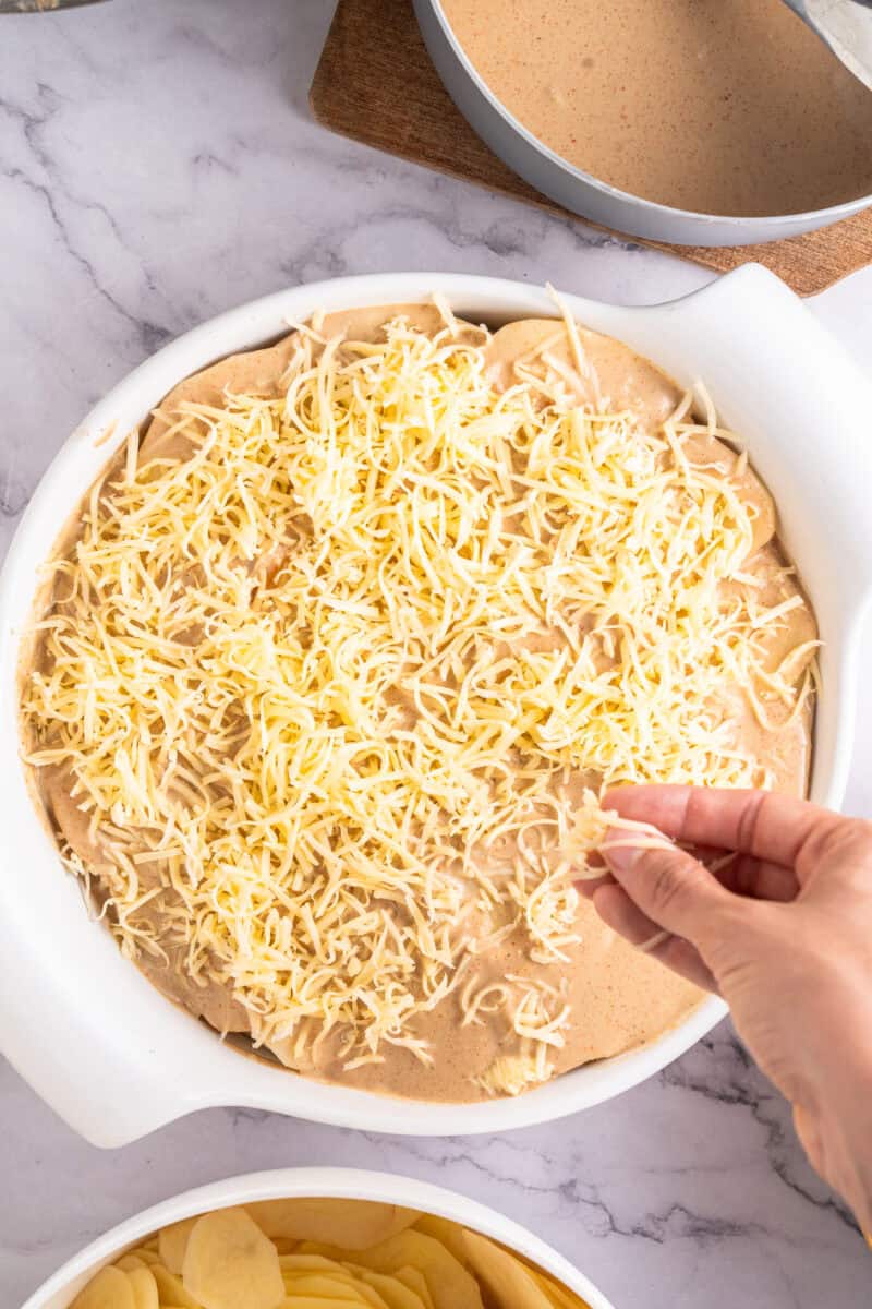 Sprinkling cheese over hamburger potato casserole