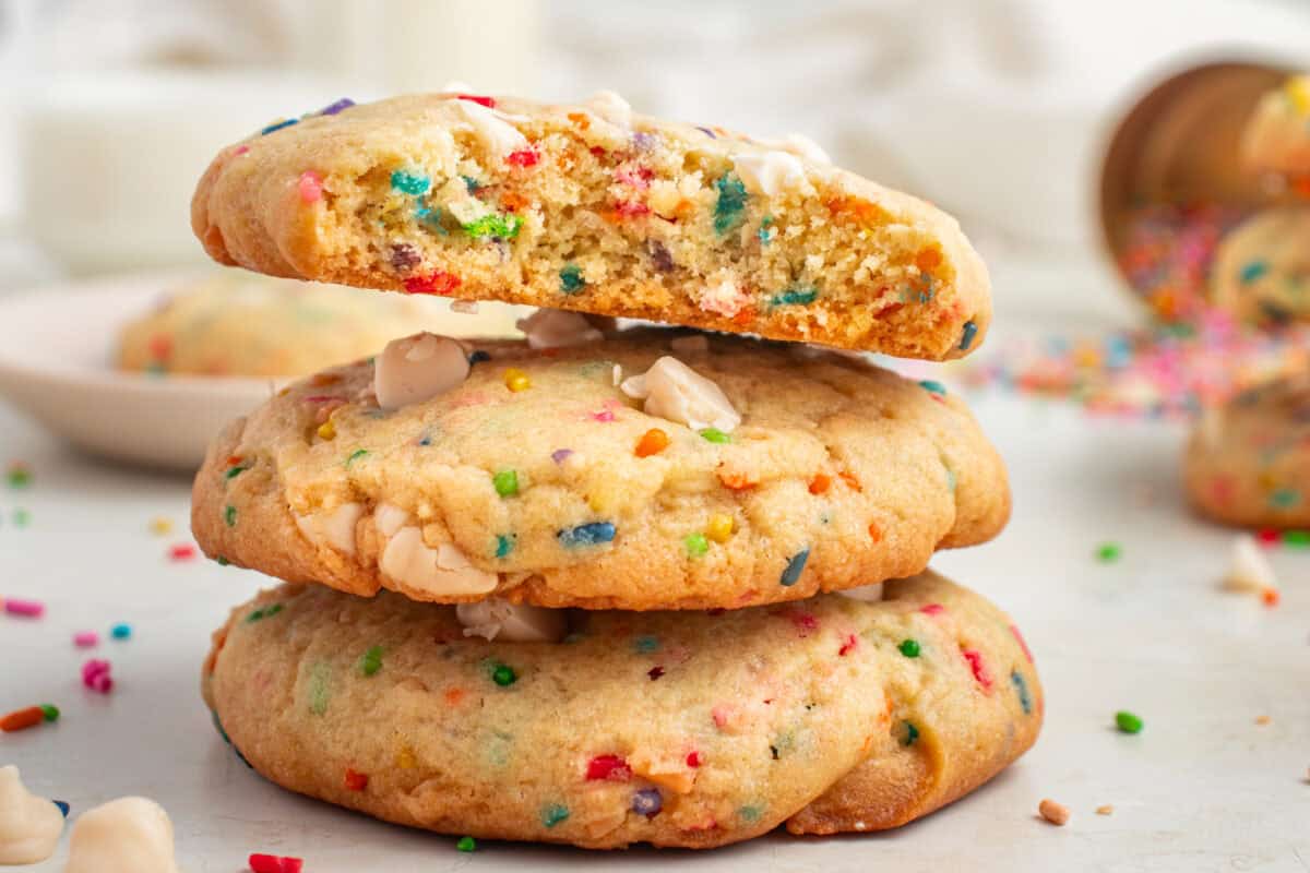 Stack of 3 virthday cake cookies with the top one broken in half