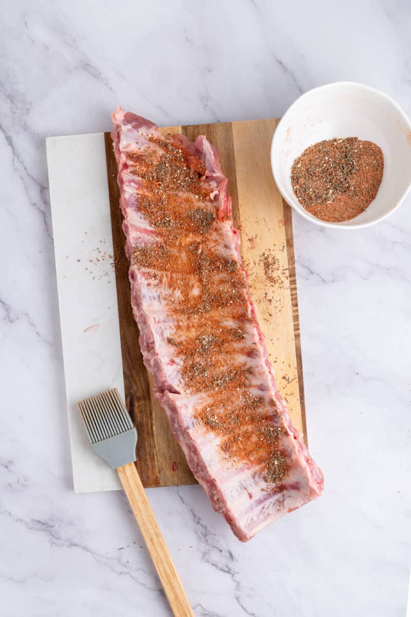 Seasoned baby back ribs on a chopping board