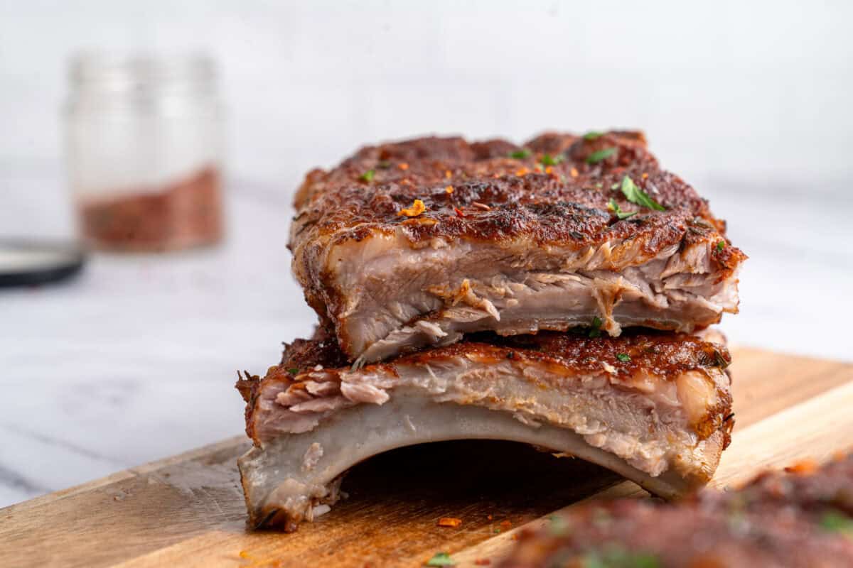 Instant Pot ribs stacked on top of each other on a chopping board