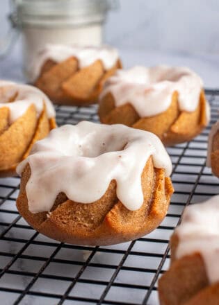 Mini pumpkin bundt cakes, glazed on a cooling rack